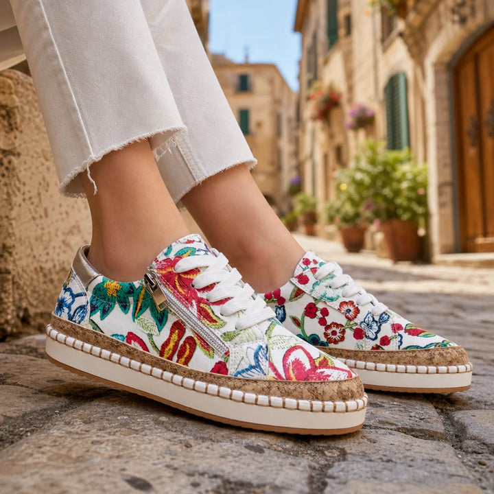 Floral platform sneakers with cork trim worn on a sunny Italian street.